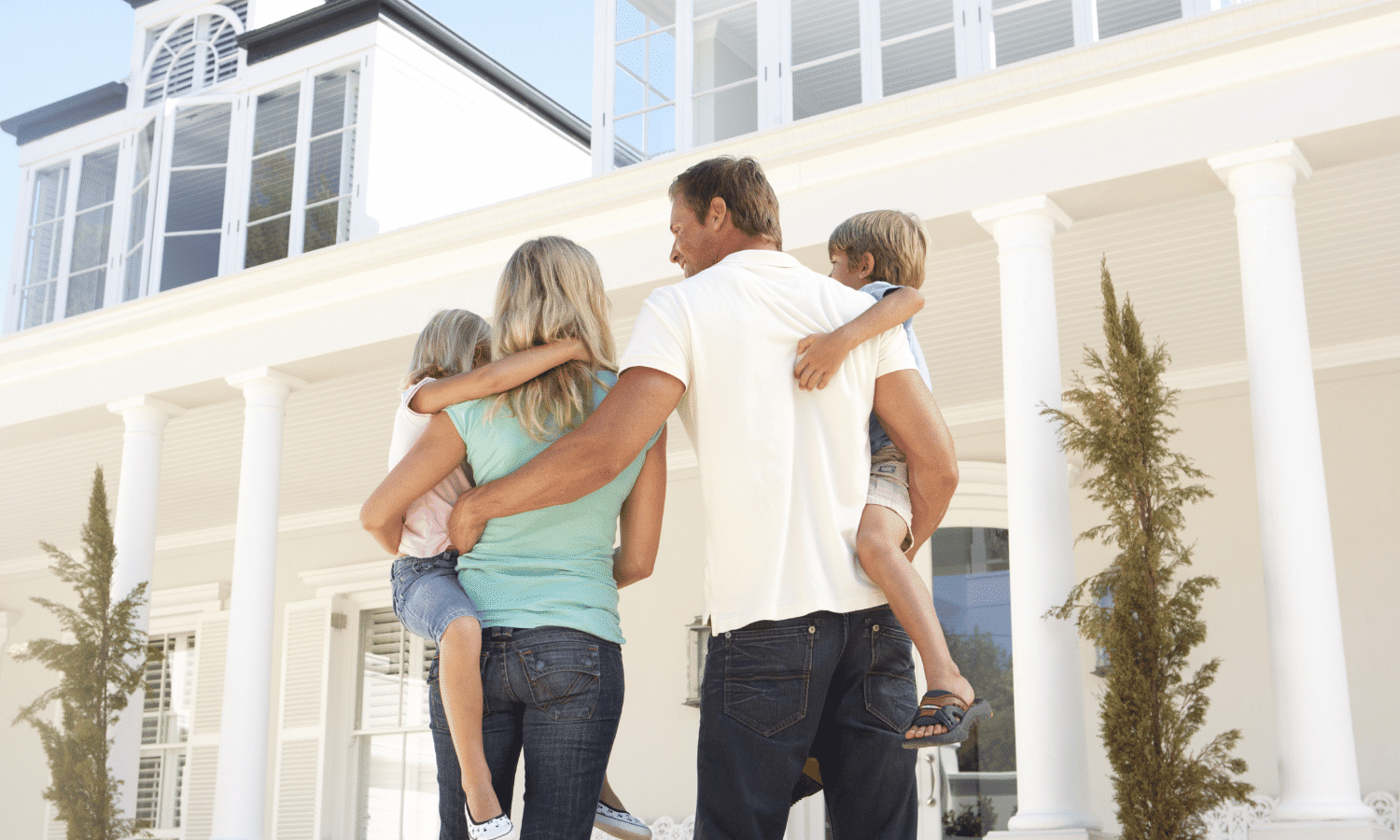 Family standing outside of their new home after closing.