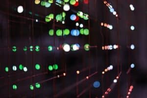 Professional looking at a complex, glowing futuristic data interface in a modern, dark room, representing the future of ma...