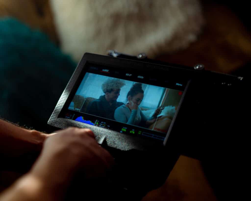 Professional real estate agent in a modern setting, holding a tablet that displays a high-quality image of a house listing...