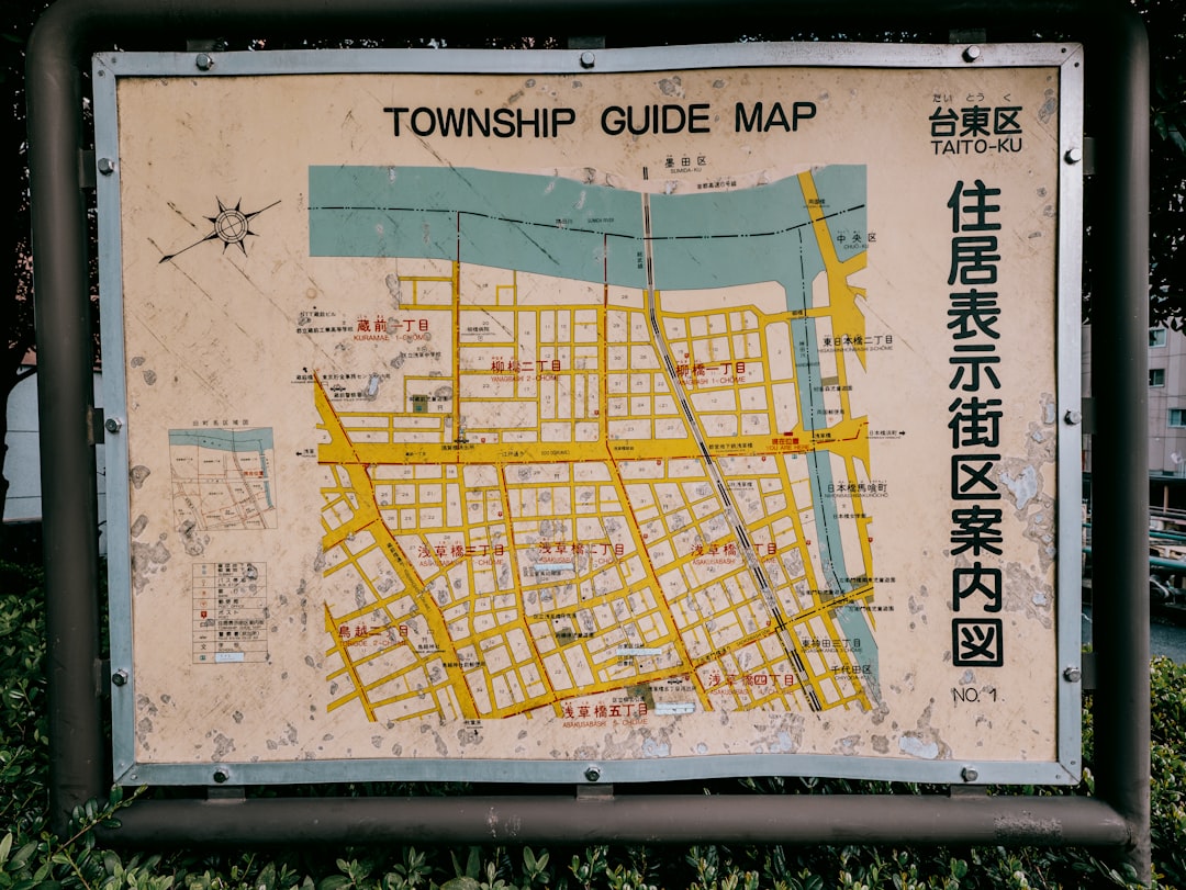 A close-up of a hand holding a smartphone, with the screen showing a detailed map of a local residential neighborhood, representing a hyper-local marketing strategy.