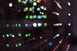 Professional looking at a complex, glowing futuristic data interface in a modern, dark room, representing the future of ma...