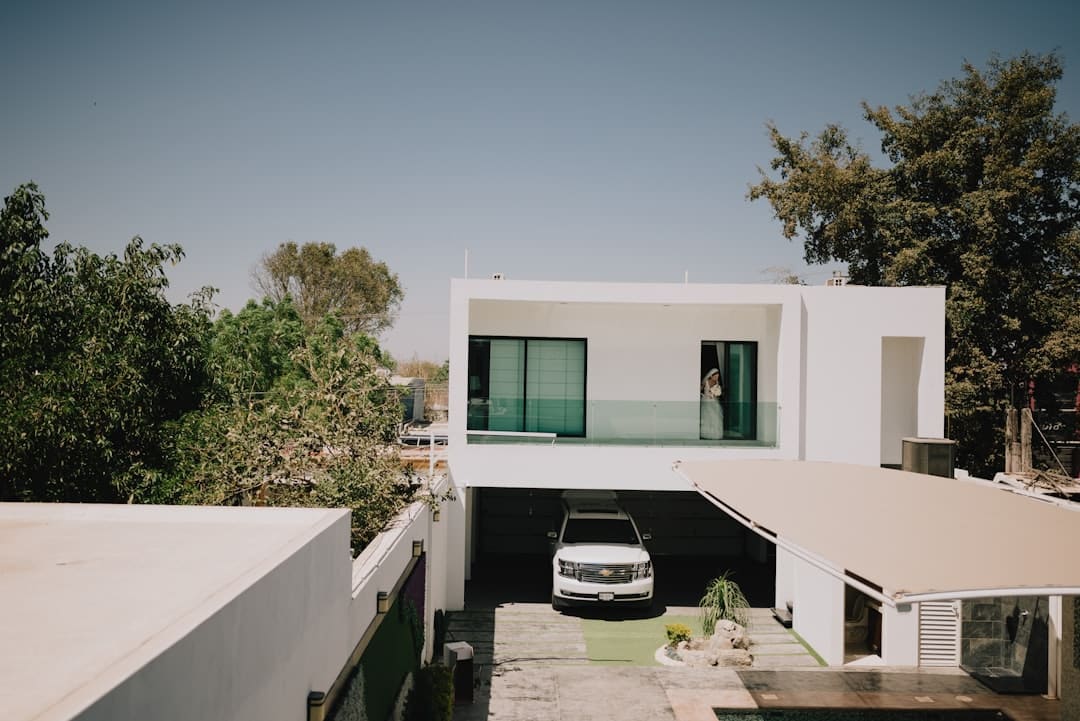 The sleek, minimal exterior of a modern luxury home on a bright sunny day, representing the perfect property found through AI-driven real estate services.