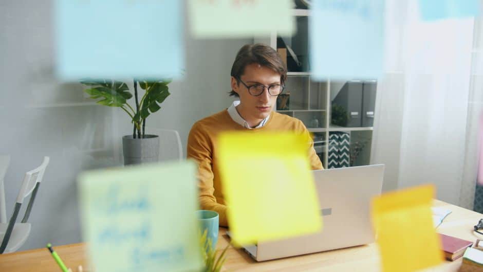 A clean and organized array of colorful sticky notes on a glass wall in a modern office, symbolizing the strategic structuring of content from keywords into concepts.