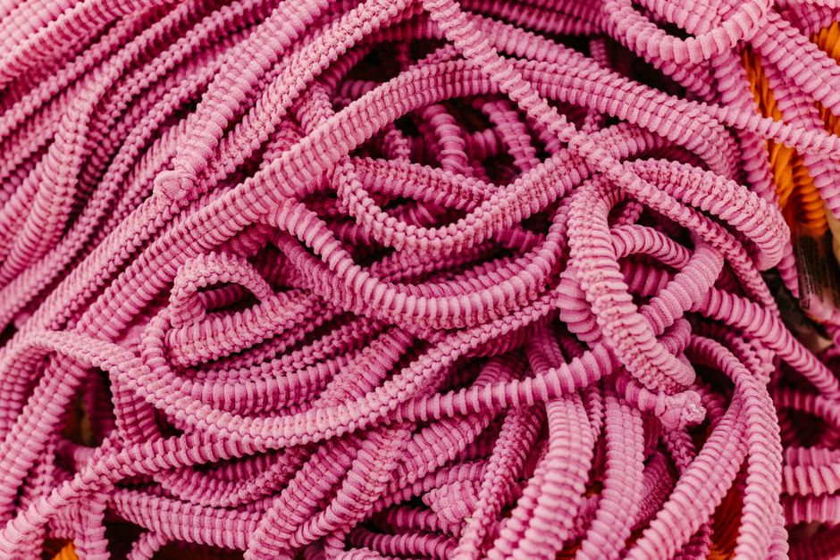 A macro photo showing many colorful threads intertwined to create a complex pattern, symbolizing how individual topics can be woven into a comprehensive concept.