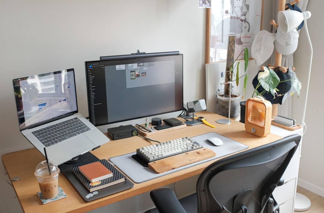 A minimalist and organized workspace shows a laptop, tablet, and phone working together, illustrating marketing automation and efficiency for small businesses.