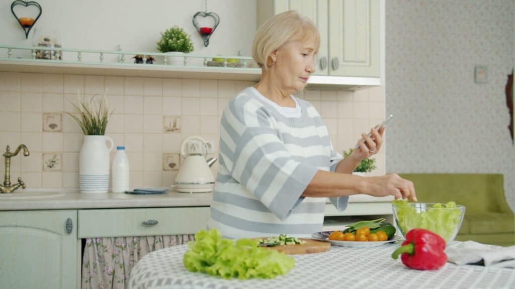 Professional real estate agent stands in a bright, modern kitchen, using a tablet to showcase property data, symbolizing t...