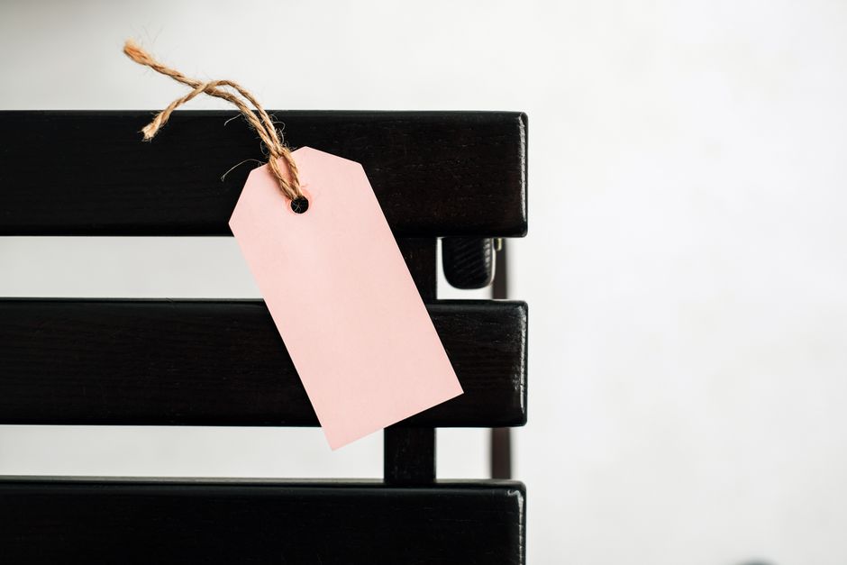 A single, clean price tag with no numbers on it hanging against a dark, moody background, representing the lack of transparent pricing in the SEO industry.