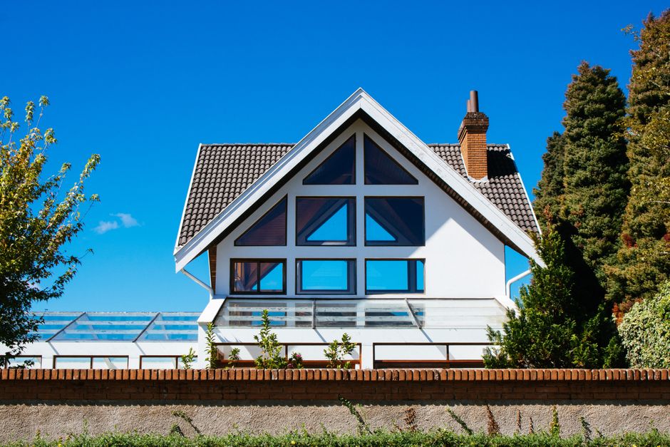 Brand new, professionally installed dark shingle roof on a modern suburban house, showcasing durability and curb appeal.