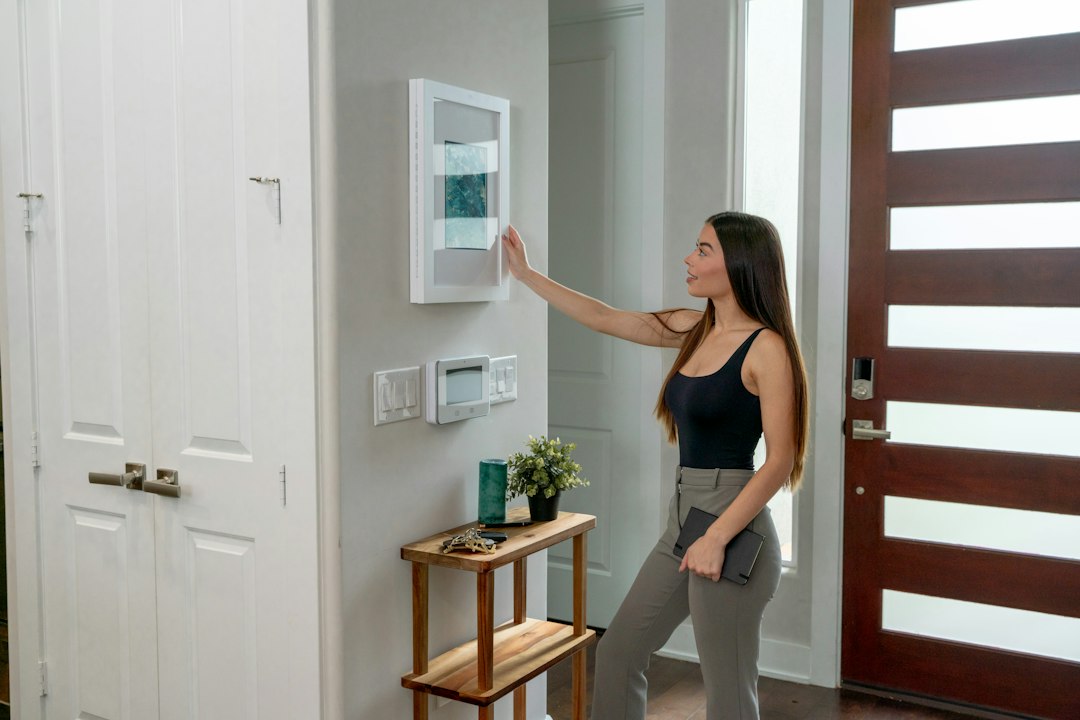 A person's hand adjusts the temperature on a modern smart thermostat, symbolizing energy efficiency and control over home comfort.